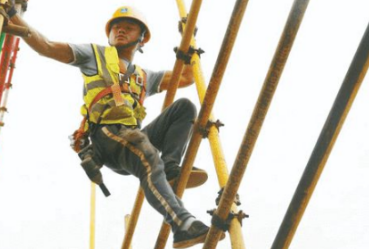 陳江山的工作是戴上高空作業(yè)安全帶在工地搭架子